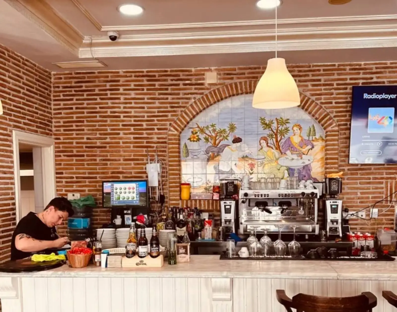 Barra interior de la cafetería con pared de ladrillo