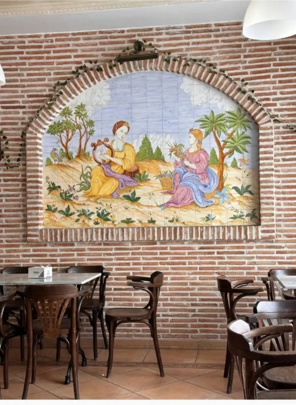 Mural de azulejos decorativo en la pared de ladrillo